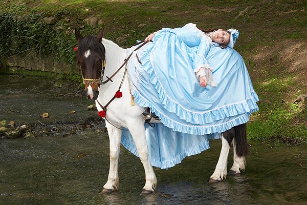 Eloise couchée sur son cheval au milieu de la rivière